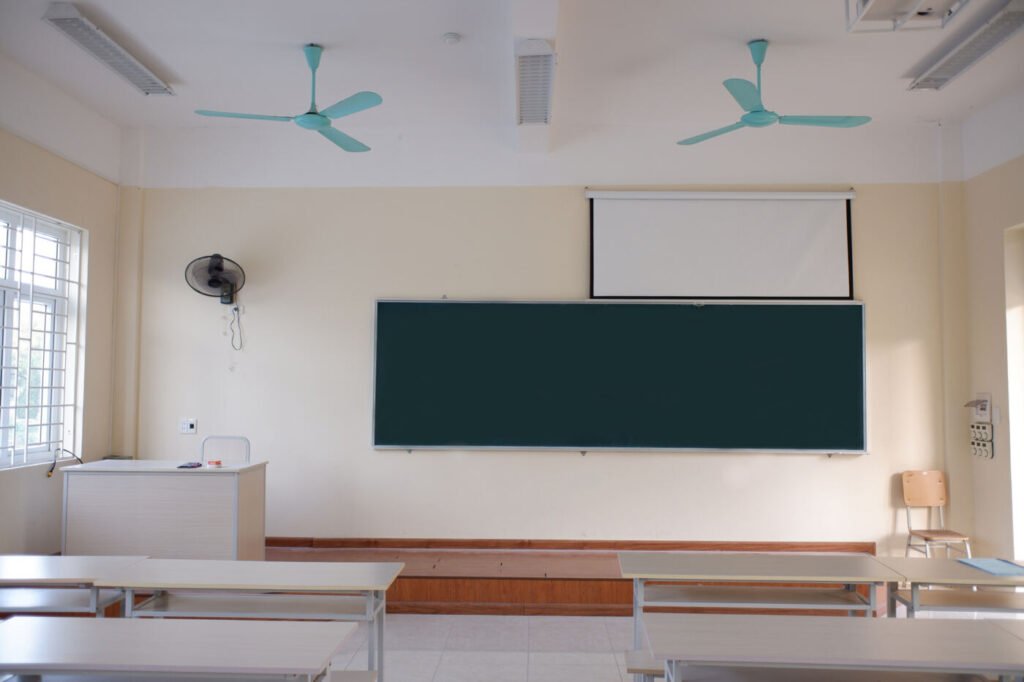 A Maakum classroom with a green chalkboard and desks ready for a lesson