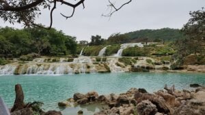 Waterfalls and green hillsides at Wadi Darbat near Salalah during the khareef